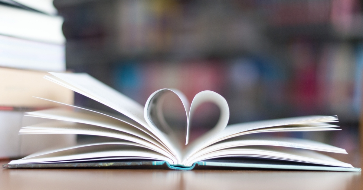 Open book with pages forming a heart shape, symbolizing the love for reading and the transformative power of literature in learning.