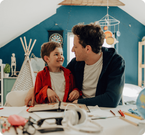 Homeschool Organization - DKM Homeschool Resource Father and son sitting at a desk homeschooling.